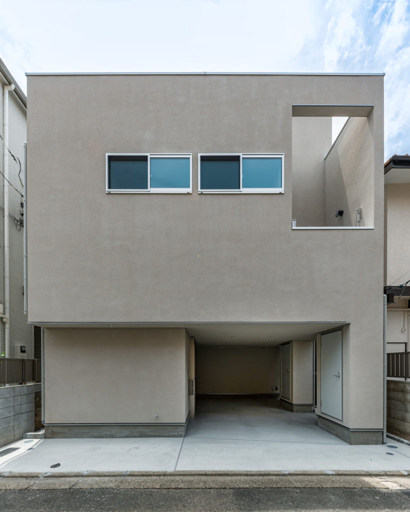 目黒区の注文住宅「中町の家」のプレーンな左官仕上げファサードとインナーガレージ