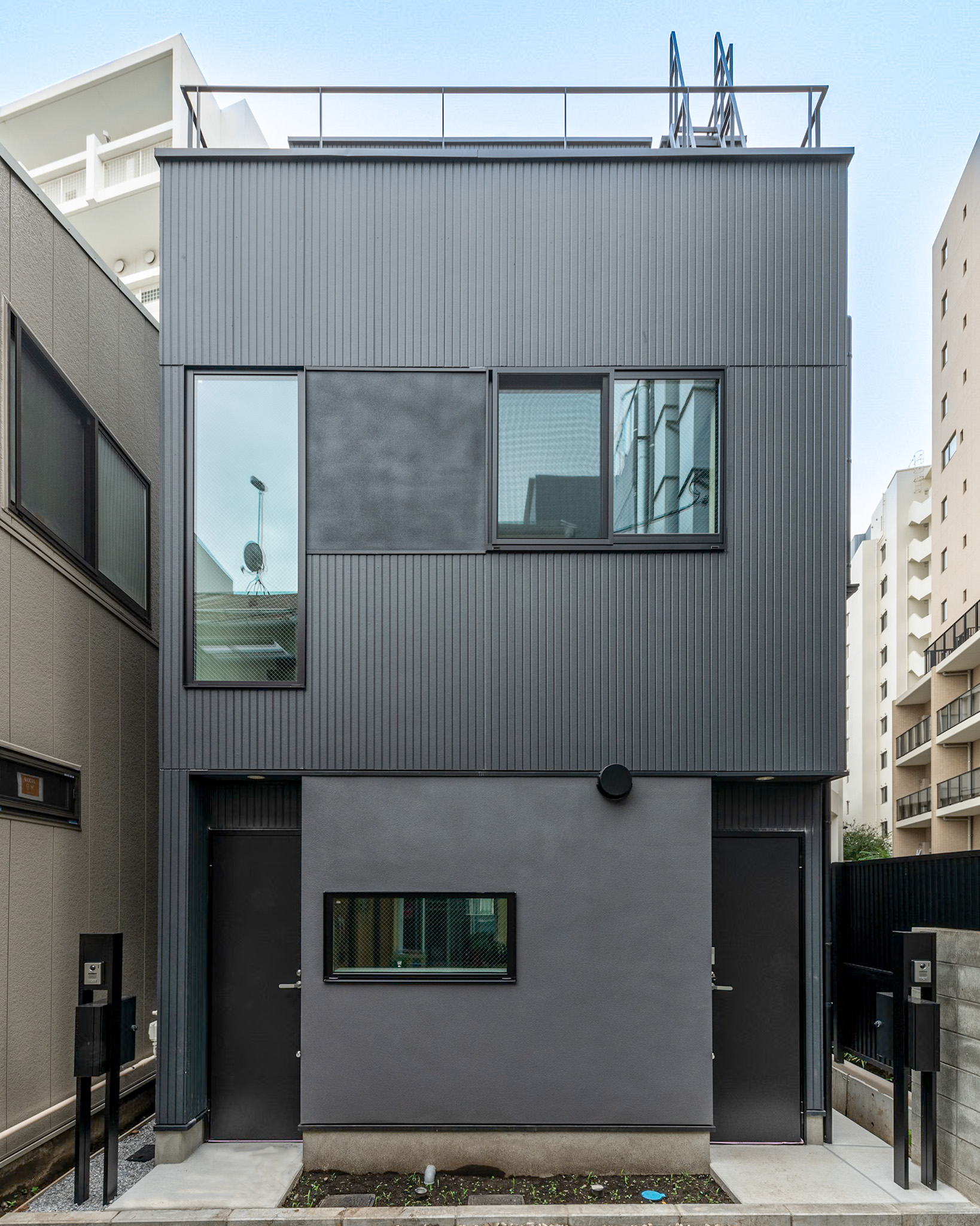 渋谷区の注文住宅「広尾の家」のシックなダークファサードと左右対称の玄関ドア