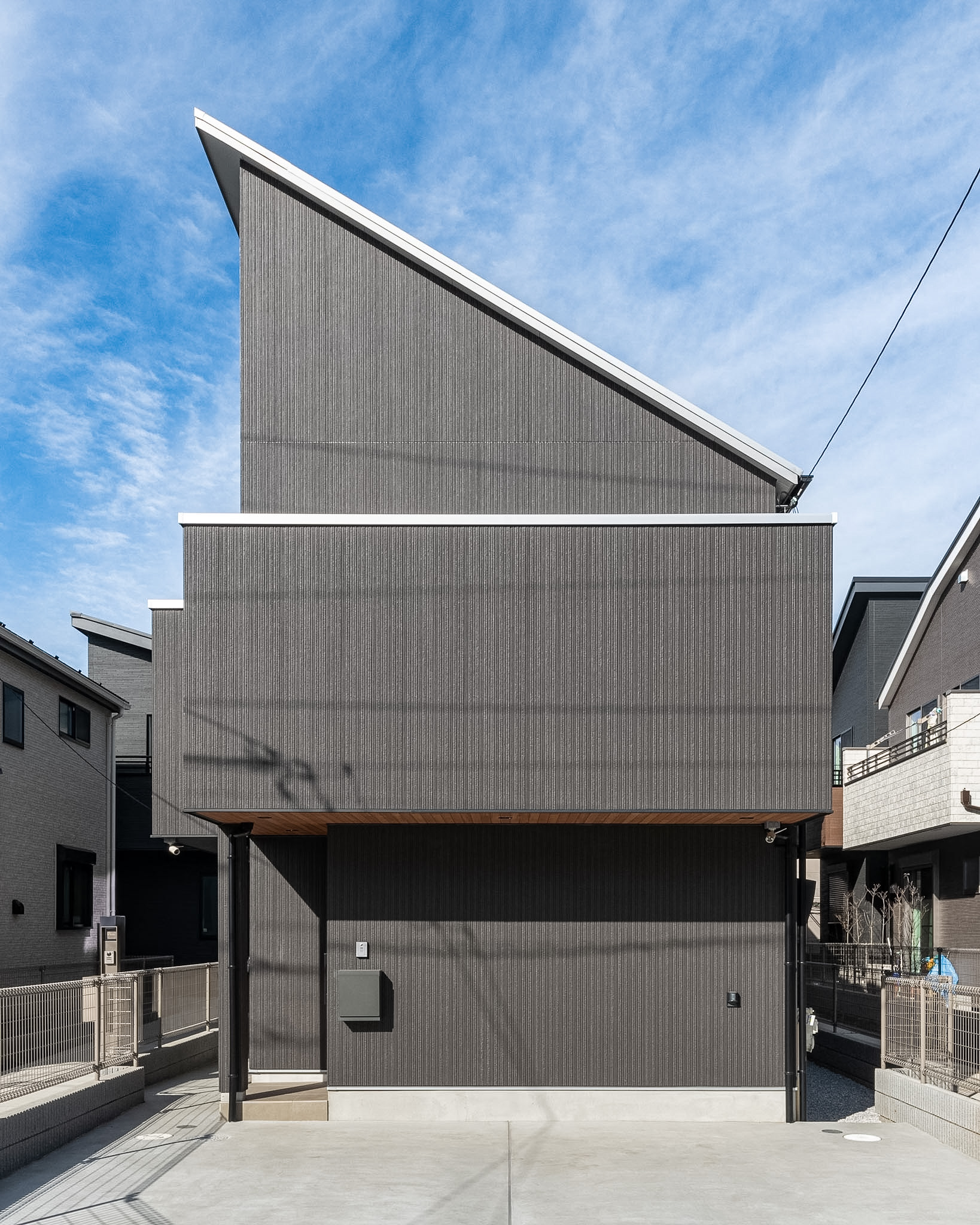 東京の注文住宅「gakuyaの家」のシャープな片流れ屋根とダークトーンの外観ファサード