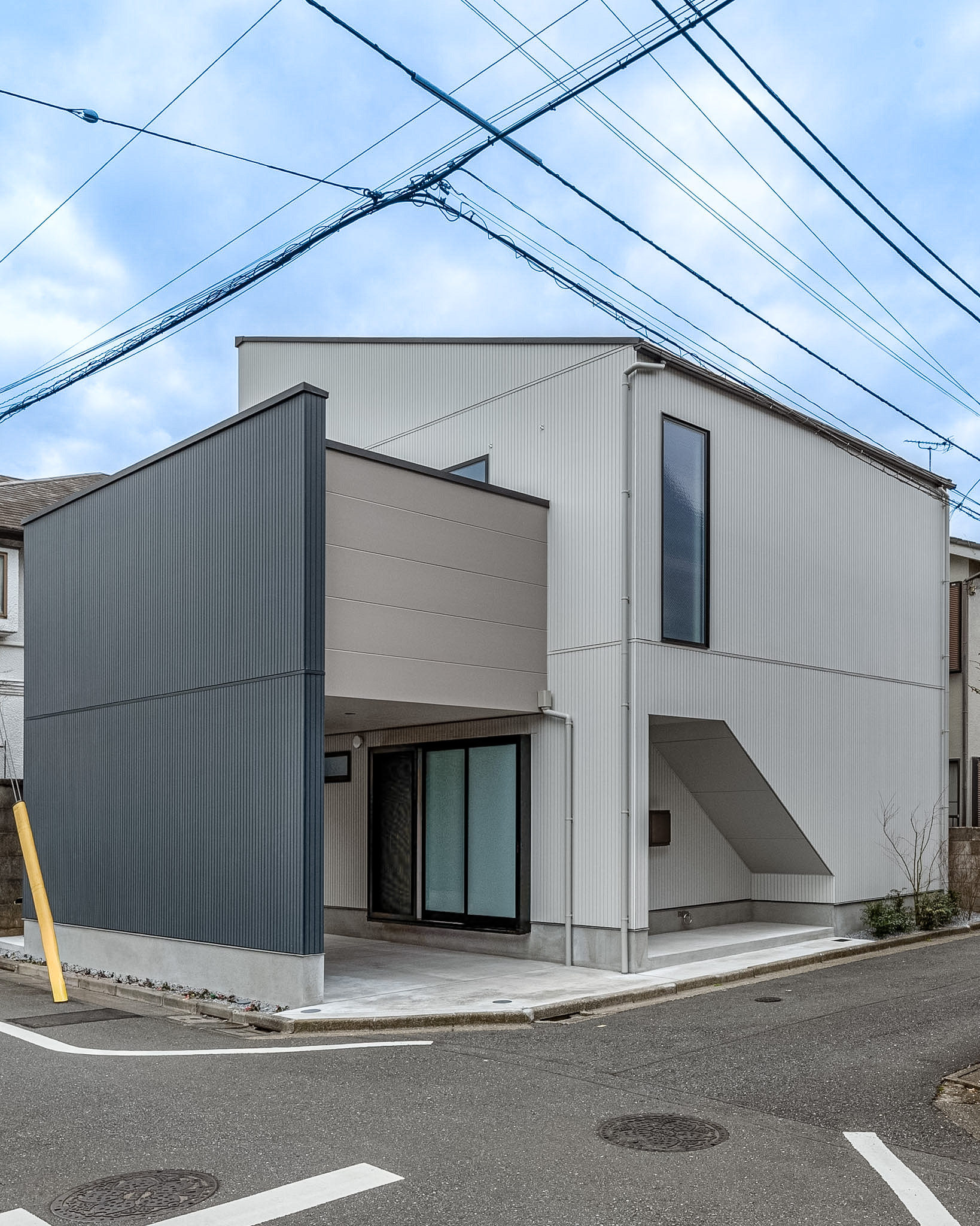 東京の注文住宅「東京の家」の多面的な幾何学ファサードとインナーガレージ