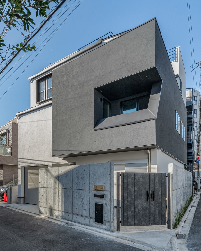 世田谷区の注文住宅「砧の家」の重厚なRC打ち放し塀とチャコールグレーの幾何学ファサード